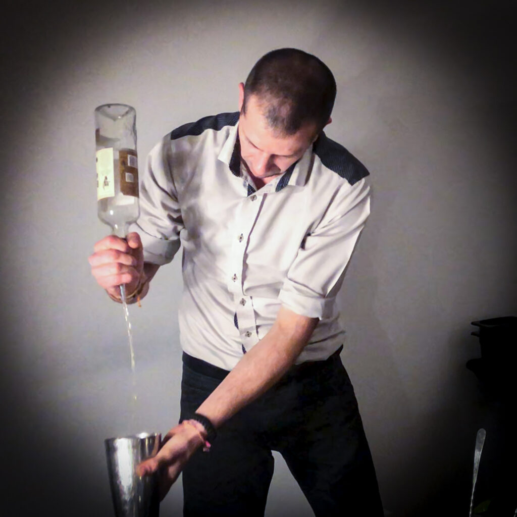 Barman préparant des cocktails devant les invités