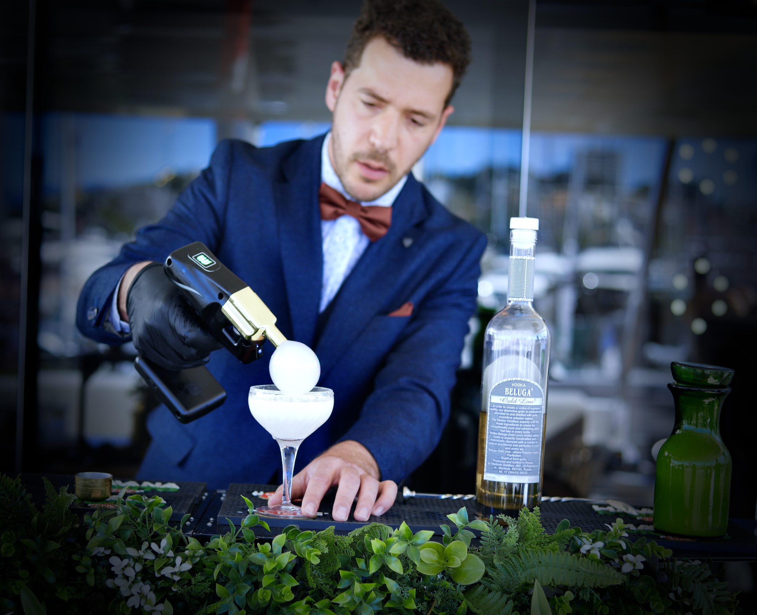 Barman en costume réalisant la finition d’un cocktail