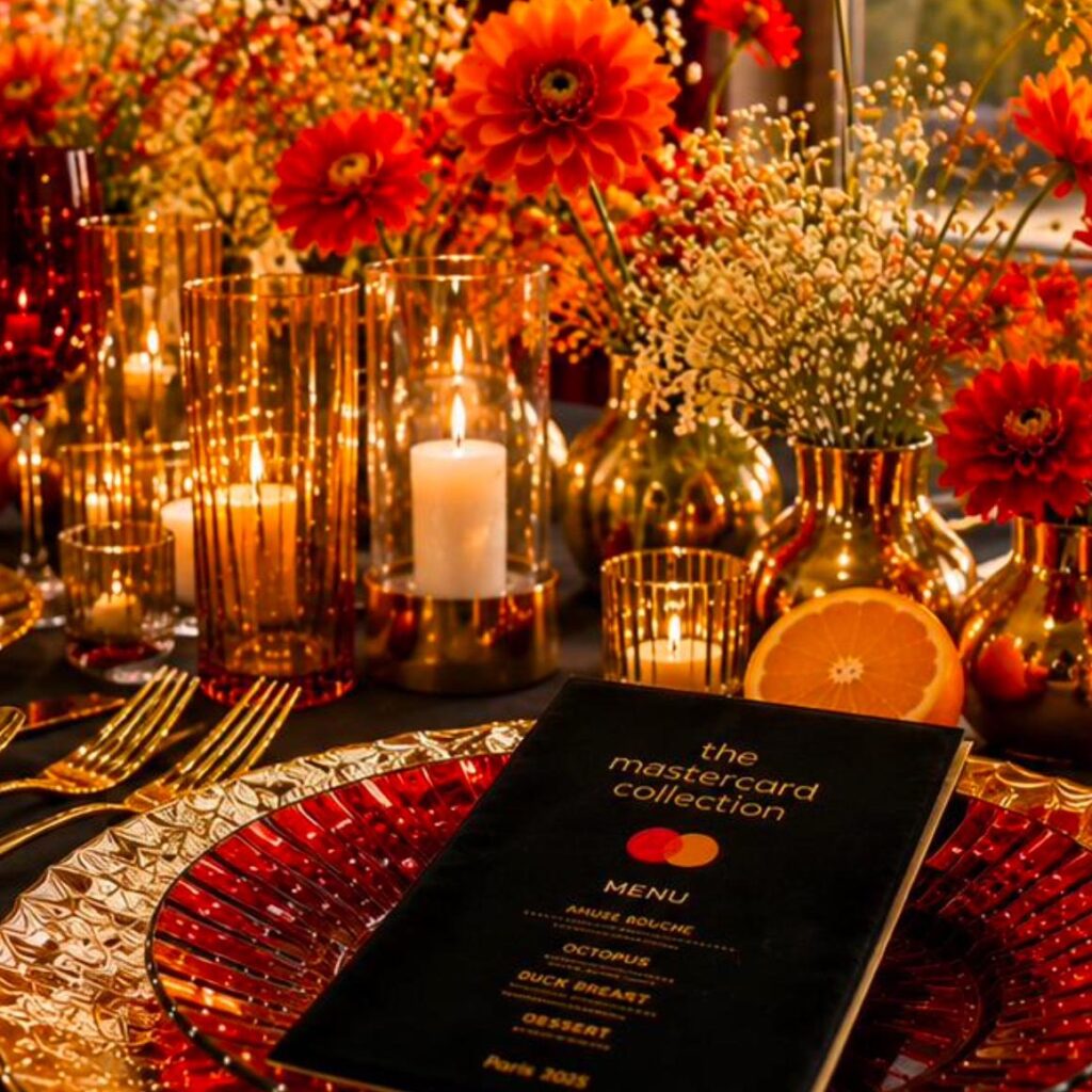 Menu Black and Gold Mastercard sur table fleurie pour une experience cocktail So Barman