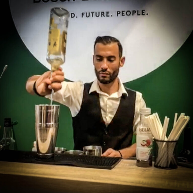 Barman versant un ingrédient dans un shaker sur le stand Bösch Boden Spies