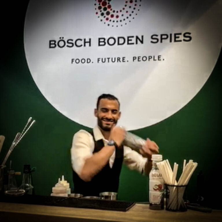 Barman agitant un shaker derrière le comptoir Bösch Boden Spies